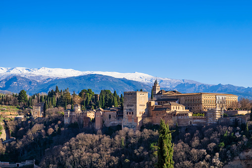 The Alhambra Overlooks The City Of Granada, Spain In Andalusia With The Sierra Nevada Mountains In The Background.