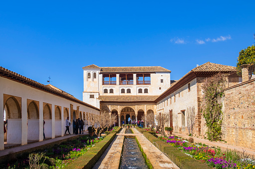 Tourists visiting the Patio de la Acequia, part of the Generalife in the Alhambra of Granada, the main landmark of the city and one of the most famous monuments of Islamic architecture in the world
