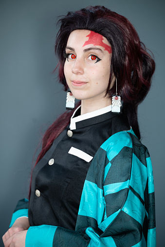 A Caucasian female cosplayer in a blue costume with face paint and red contact lenses