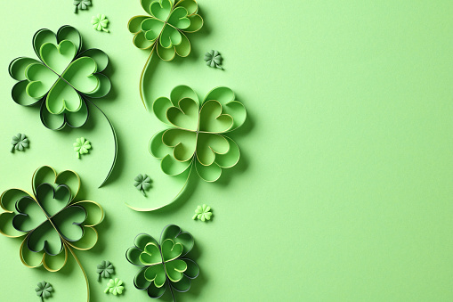 Four leaf clover paper cut on green background. St Patrick's Day greeting card design.