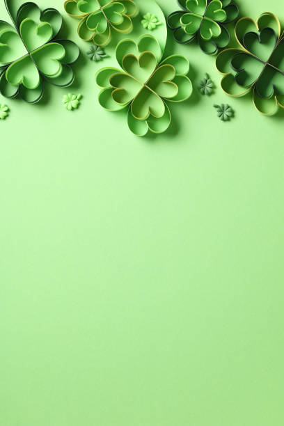 istock St Patricks Day vertical background, poster template. Frame top border made of handmade paper cut clover leaves on green background. 1916609680