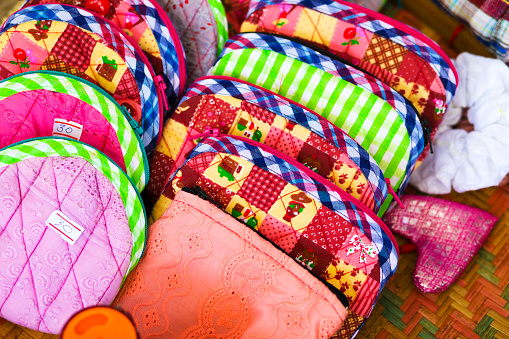 Colorful homemade small thai purses offered in small village Paranghmee near Noen Maprang in Phitsanulok province. Purses are placed on a table outside of a house selling homemade thai products