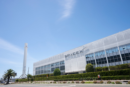 Hawthorne, CA, USA - May 10, 2022: Exterior view of the SpaceX headquarters with recovered Falcon 9 rocket booster on display in Hawthorne, California. SpaceX is an American aerospace manufacturer.