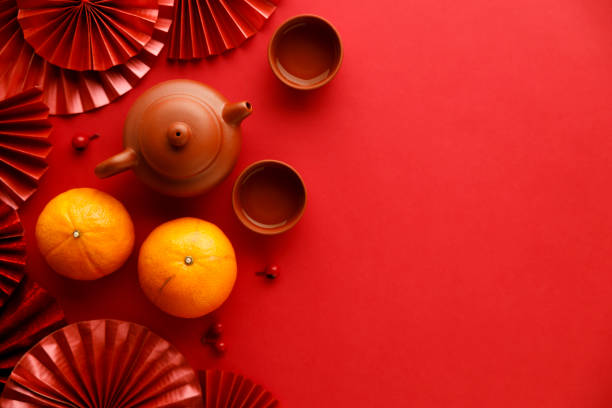 к�итайские новогодние праздничные украшения с мандаринами, классическим глиняным чайником и красными китайскими сложенными веерами. - 6728 стоковые фото и изображения