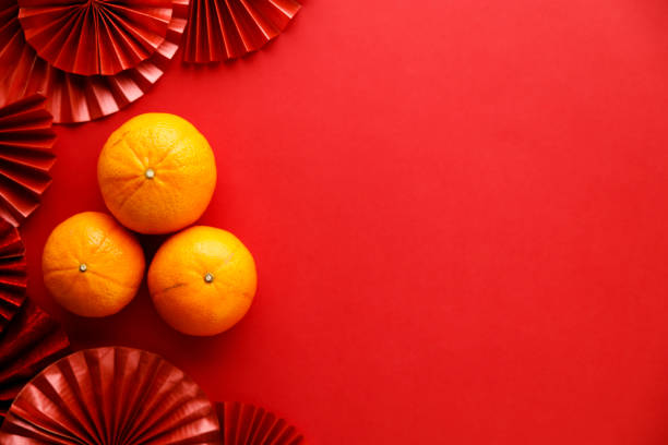 Chinese new year festival decorations with tangerines and red Chinese folded fans. Chinese new year festival decorations with tangerines and red Chinese folded fans on red background. Celebrate Happy Chinese new year background concept. Top view. mandarin chinese new year stock pictures, royalty-free photos & images