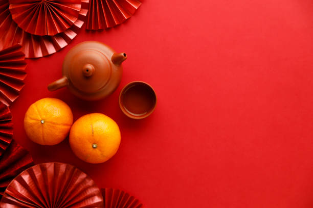 chinese new year festival decorations with tangerines, classic clay teapot and red chinese folded fans. - 6726 imagens e fotografias de stock