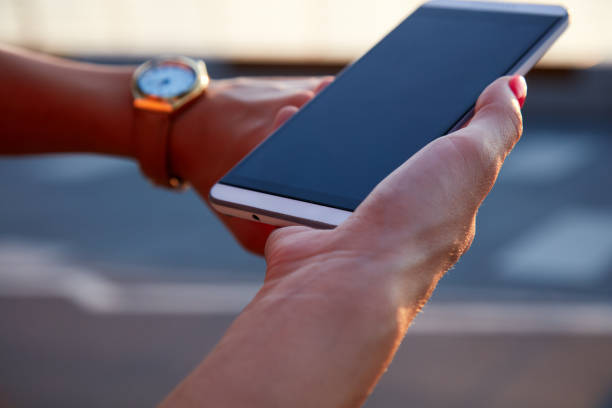 istock Woman holding cellphone outdoors in sunset time. 1916703051