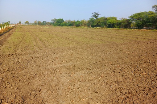 Plowed agricultural field with cultivated fertile soil prepared for planting crops in spring.