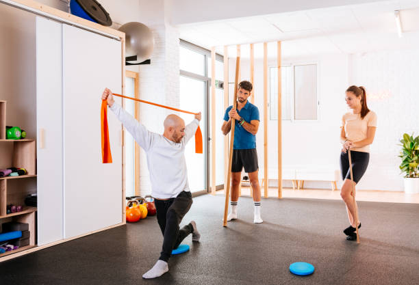 istock Trainer explaining how to do exercise with resistance bands in a gym class 1916716658