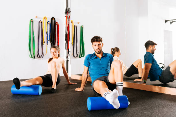 istock Young male and female doing exercises on foam roller in gym 1916717704