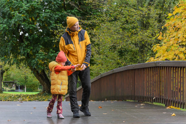 istock father and five-year-old daughter in fall park on bridge 1916719842