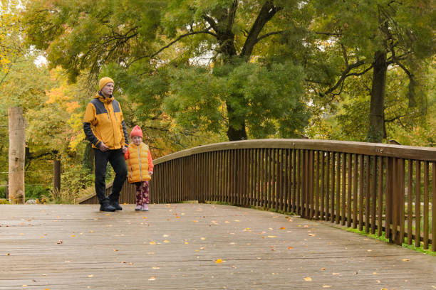 istock father and five-year-old daughter in fall park on bridge 1916721921