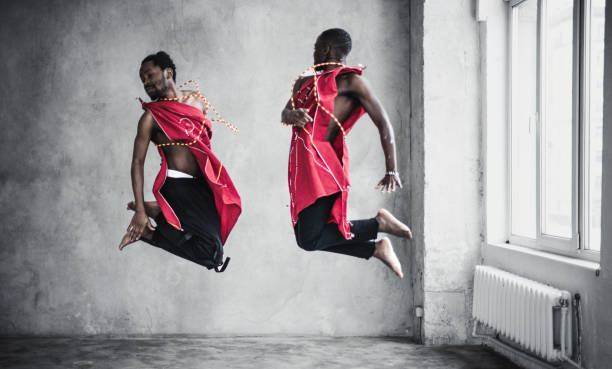 istock Two black young men in traditional costumes dancing in an empty room 1916724498