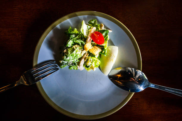 caesar salad of 
lettuce, grilled chicken breast, croutons, boiled egg, cherry tomatoes served in a bowl - salad caesar salad main course restaurant foto e immagini stock