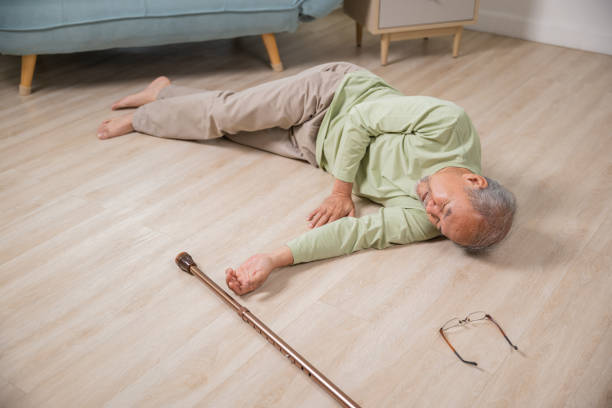 istock Asian senior man falling down lying on floor at home alone with wooden walking stick 1916760102