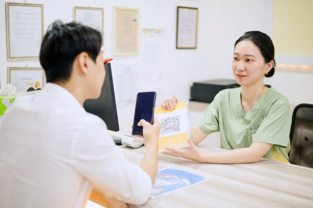 asian chinese male using credit card to make payment in dental clinic. - dentist office built structure doctors office retail - fotografias e filmes do acervo