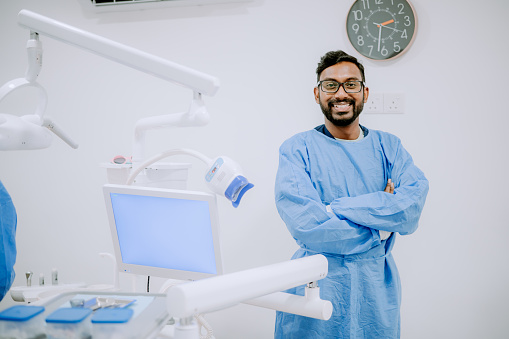 Asian Indian male dentist in dental clinic.