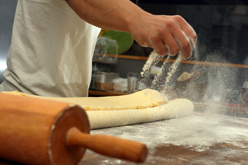 Confectioner sprinkles the flour while kneading the dough and empty space for text