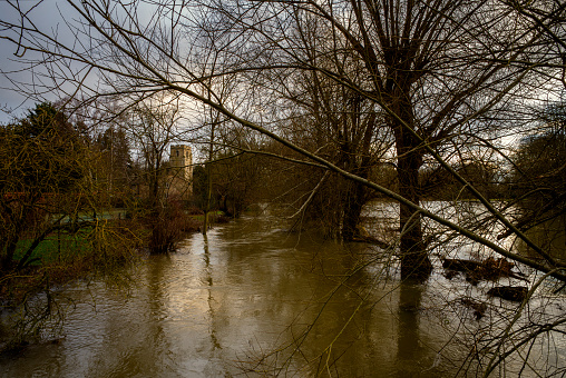 Sun setting on All Saints Church in Harston, with a flooded River Cam in the foreground.