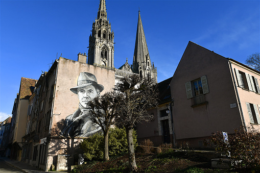 Chartres, France-01 05 2023: The cathedral district in Chartres and a mural representing Jean Moulin, former prefect of the department and hero of the french resistance.