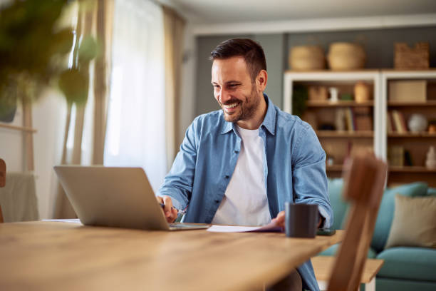 istock A smiling freelance man reading good feedback on his project on a laptop while working from home. 1916804571