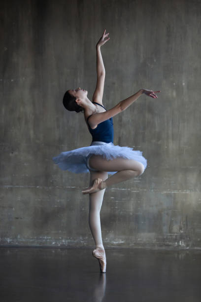 istock Young ballerina in a white tutu in a graceful pose 1916819373