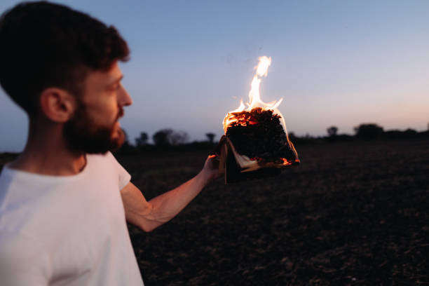 istock Symbolic Act: Man Holds Burning Book in Hands 1916845025