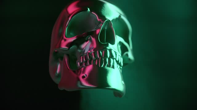 Mystical background of a metallic human skull emerging from the folds of a dark shiny fabric. 3d rendering digital animation 4K