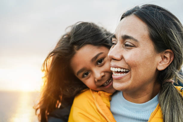 happy latin mother and daughter having fun together during winter time - mom day concept - focus on mum face - life events laughing women latin american and hispanic ethnicity imagens e fotografias de stock