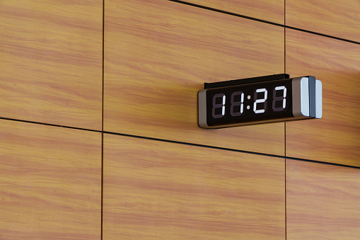 Black round wall clocks in a row on white background.\nTwelve hours