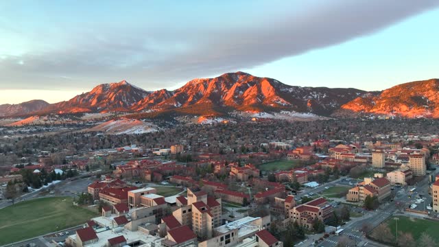Beautiful Aerial Drone Sunrise over the University of Colorado Boulder (CU Boulder) with flat irons foothill mountains in background on a winter morning.