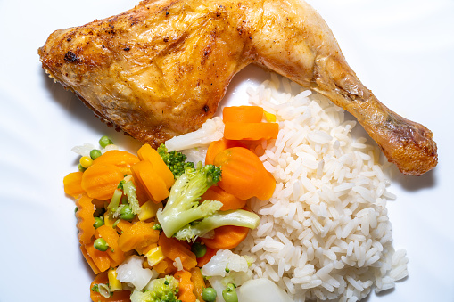 Fried chicken meat with rice and vegetables on a plate