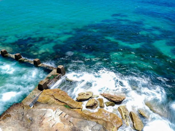 istock Powerful white swirling waves (blurred motion) crashing into rocky coastline 1916970789