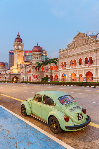Kuala Lumpur, Malaysia – 22 August, 2023: Amazing view of a vintage car on Jalan Raja in evening. The Sultan Abdul Samad Building is visible in background. Amazing cityscape.