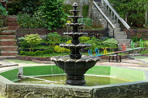 a small fountain in the children's playground, a flower-shaped fountain, flowing from top to bottom.