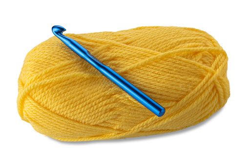 Ball of yellow-colored wool yarn with knitting weaving crochet hook 10 mm blue color isolated on white with clipping path included