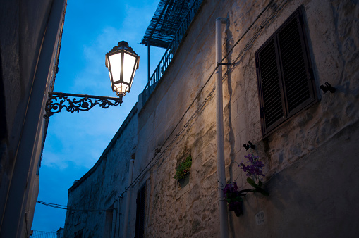 Old Street Lamp with Blue Sky in Background in Ostuni Old Town During Night. Brindisi Province, Salento, South Italy