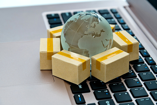 Glass globe  and small boxes on laptop keyboard.