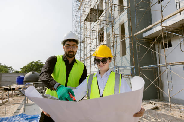 istock Engineers and Architect Caucasian looking at blueprint of building construction, planning the work in a professional. inspector is looking at steel structure and materials at construction site. 1917007285