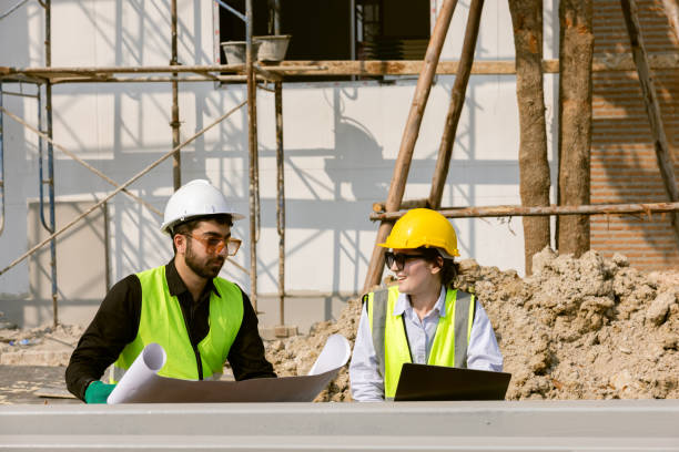 istock Engineers and Architect Caucasian looking at blueprint of building construction, planning the work in a professional. inspector is looking at steel structure and materials at construction site. 1917007308