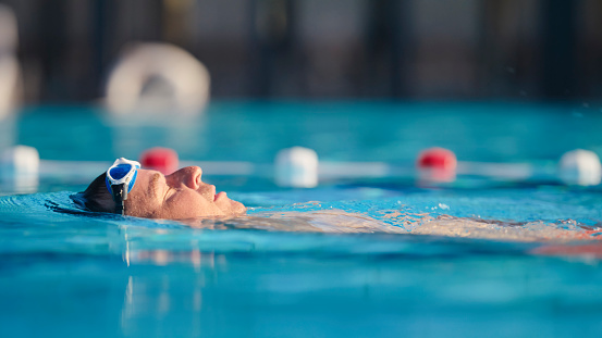 Sports, swimming and number on diving board by pool for training, exercise and workout for triathlon competition. Fitness, motivation and five on professional podium ready for dive, start and race