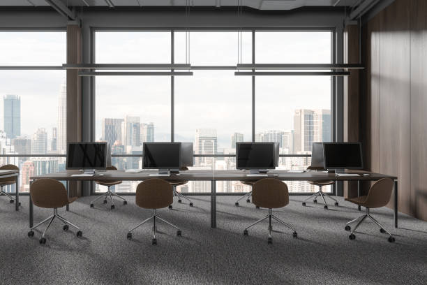 istock Modern office workspace interior with pc desktop and table in row near window 1917017446