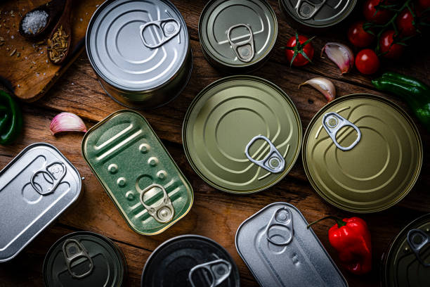 overhead view of a group of food tins on wooden table - blik container fotos stockfoto's en -beelden