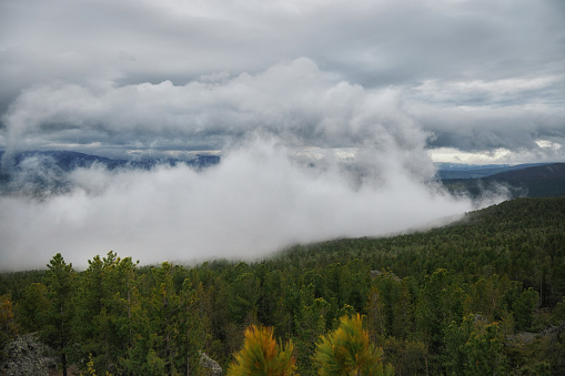 Severe weather in the Ural Mountains, Russia. Fog creeps down the mountainside, cold summer