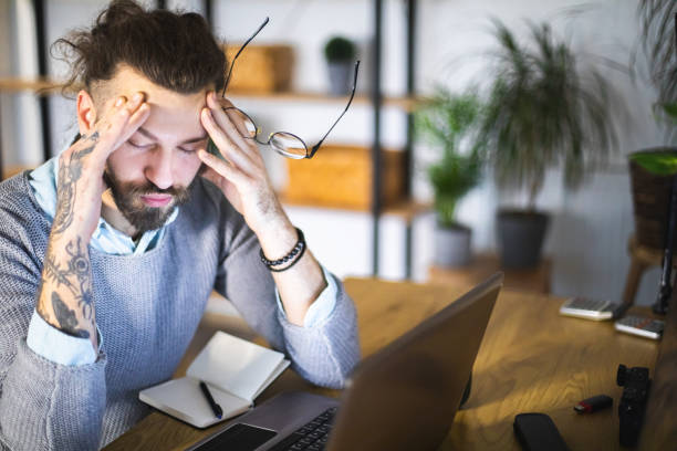 istock Young man stressing over financial bills at home 1917028274