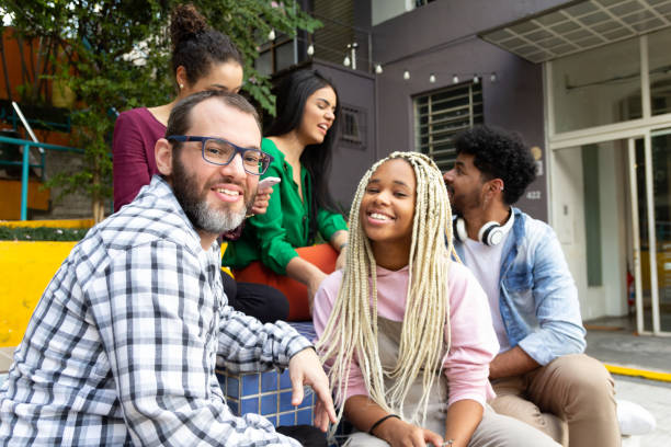 istock Happy man having fun and sitting at outdoors in public place. 1917034140