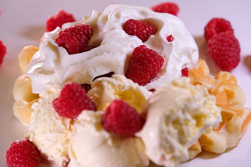 Traditional scottish cranachan with raspberry, whipped cream and cereal in glass. High quality photo