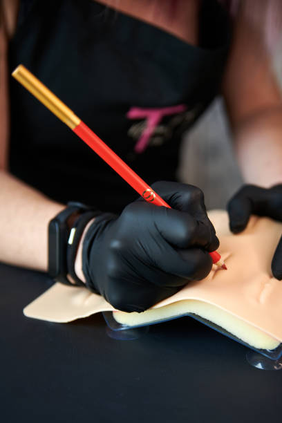 istock Beauty salon worker hands dunking the tool into the ink during microblading process 1917054249