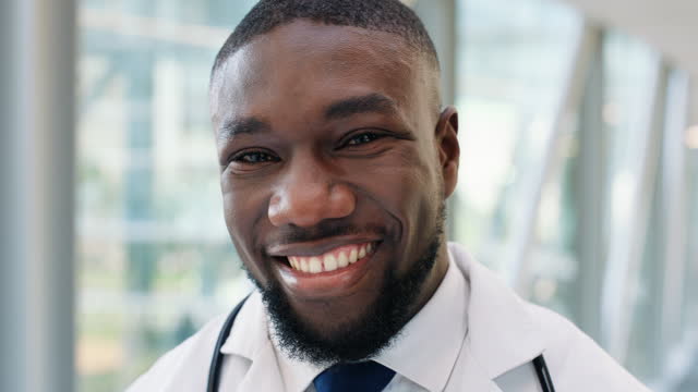 Black man, doctor and smile on face, healthcare and pride for career at hospital or clinic. Male person, medical professional and happy with insurance, portrait and consultation or trust in Nigeria