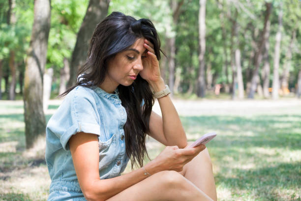istock Sad Woman  using her phone outdoor 1917059874